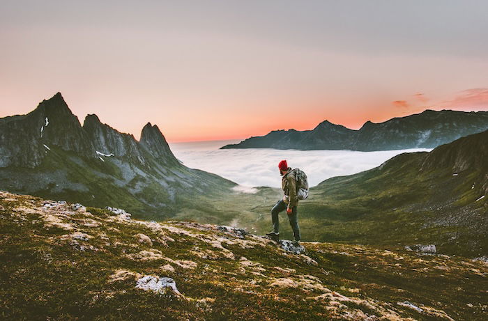 A hiker hiking in a high mountain landscape at dusk