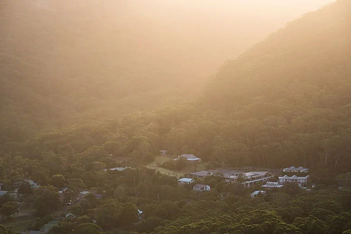 Hazy edited landscape photo of a village on a woodland hillside