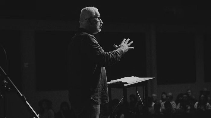 Man giving a speech on stage, as an example of event photography