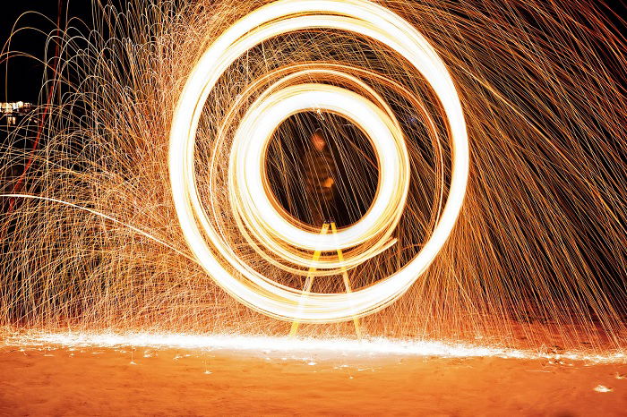 Long exposure photo of a man creating circles with a sparkler