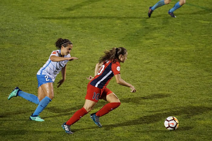 Two female football players playing football