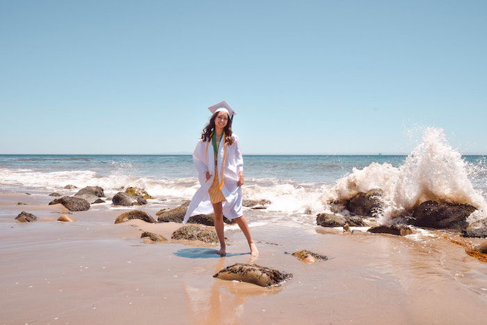 senior picture idea with a senior high-school graduate posing at a beach