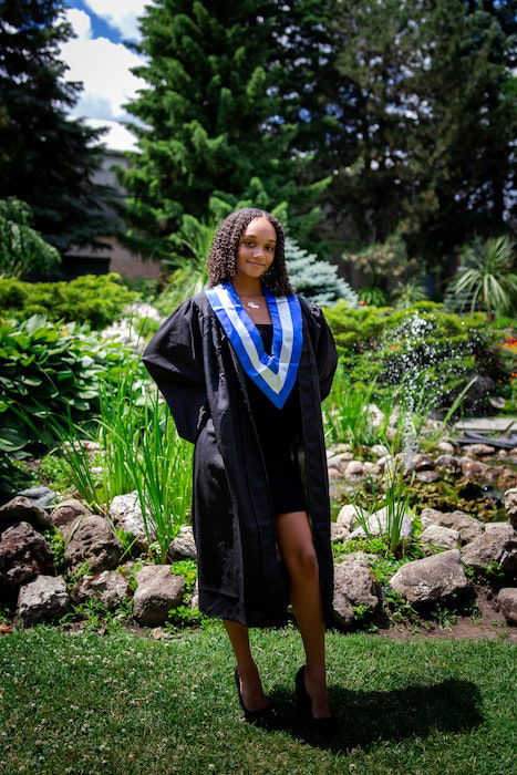 Senior high-school graduate posing in a park as a fun senior picture idea