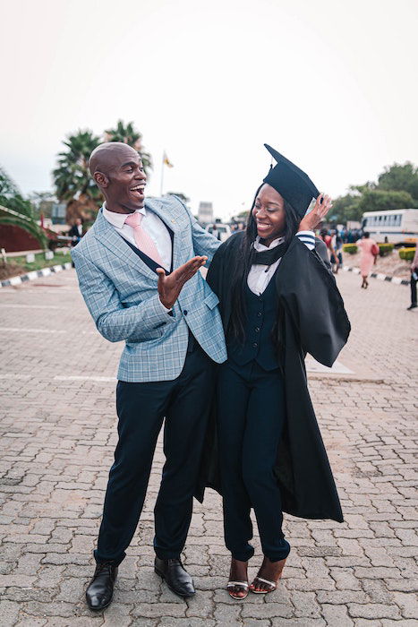 Two people smiling and laughing while embracing one another during a graduation