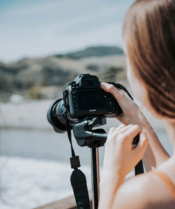 Rear view shot of a girl using a canon camera on a tripod