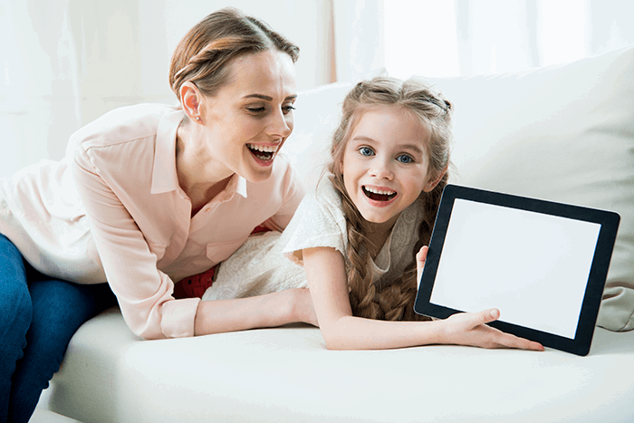 Woman and young girl showing a tablet computer