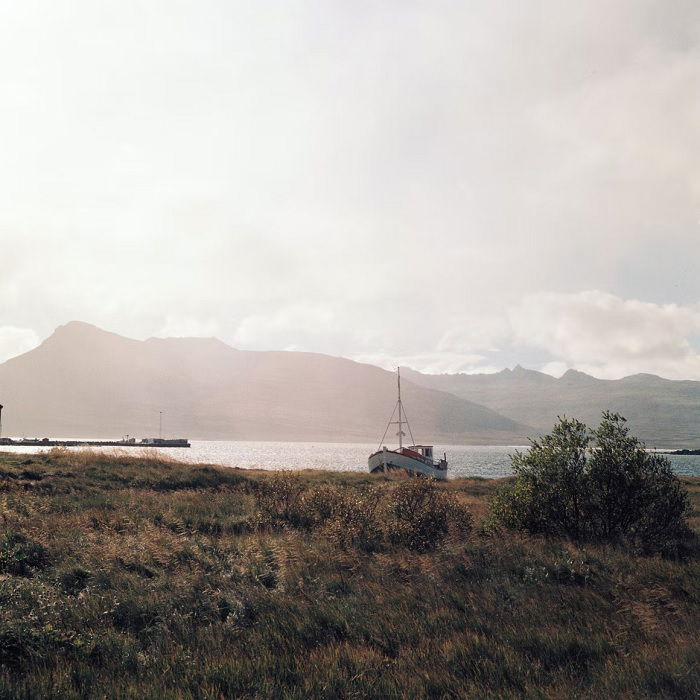 Landscape of coast with boat and mountains