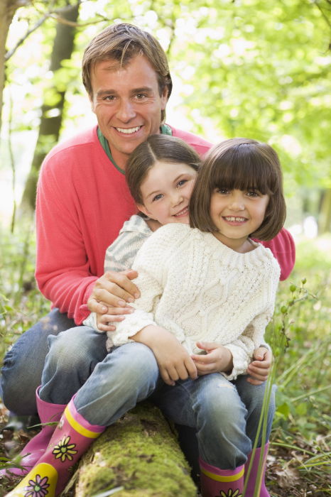 Dad and children sitting on a log