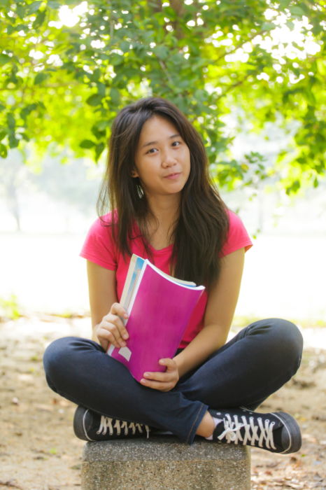 Young woman sitting on the ground posing for a photo