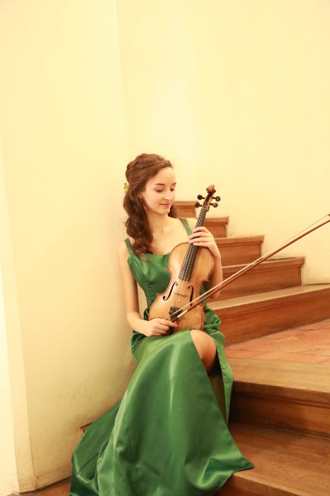 Woman sitting holding her violin