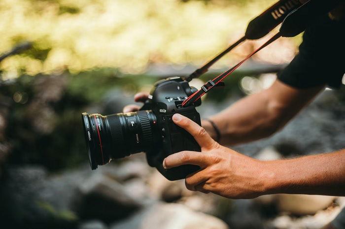 Man filming handheld using a Canon camera with a Canon STM lens