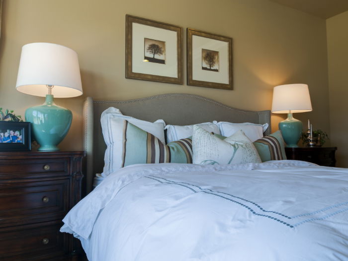 A stylish bedroom with two nicely-framed photos above the bed