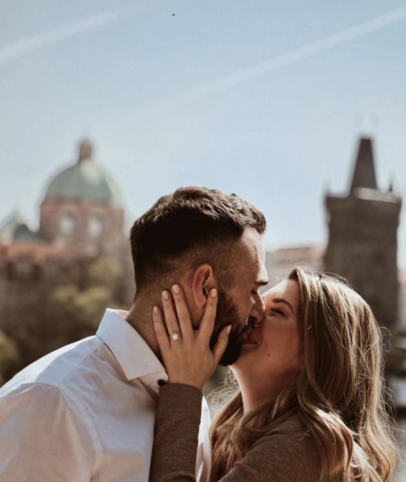 Young couple kissing by Charles Bridge, Prague