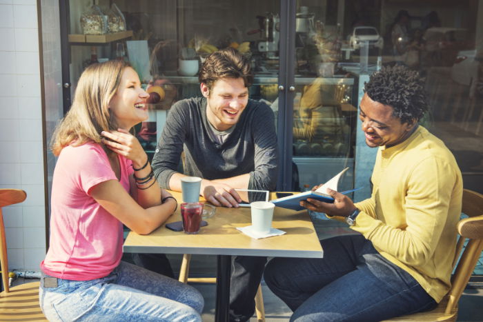 Three people meeting outside a coffee shop