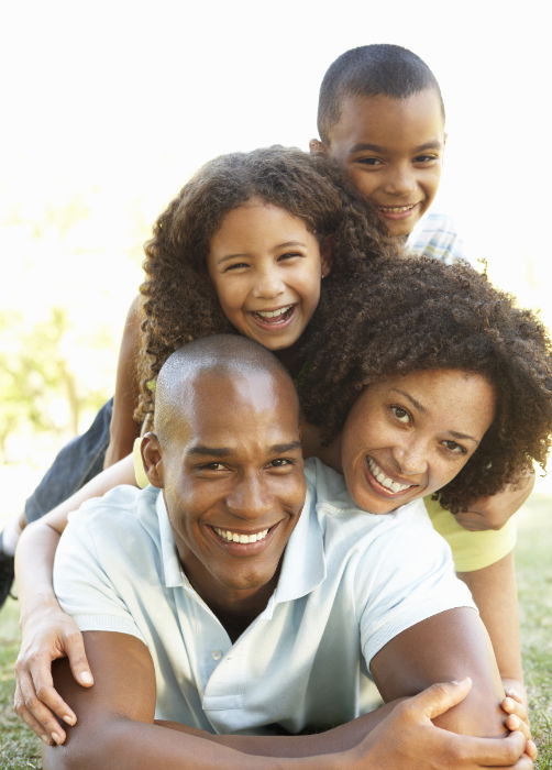 A family photo with members lying on the ground on top of each other