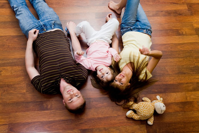 View from above of family lying on the floor and looking up at the camera