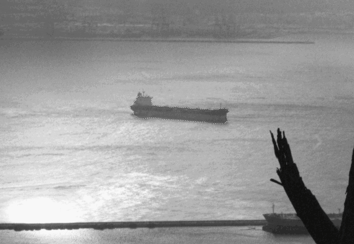 A ship crossing the ocean, viewed from the shore. 