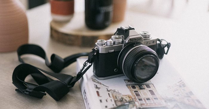 Nikon Z fc camera sitting on a book about Venice in front of house plants