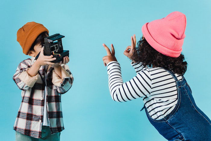 Kids taking picture on a Polaroid camera