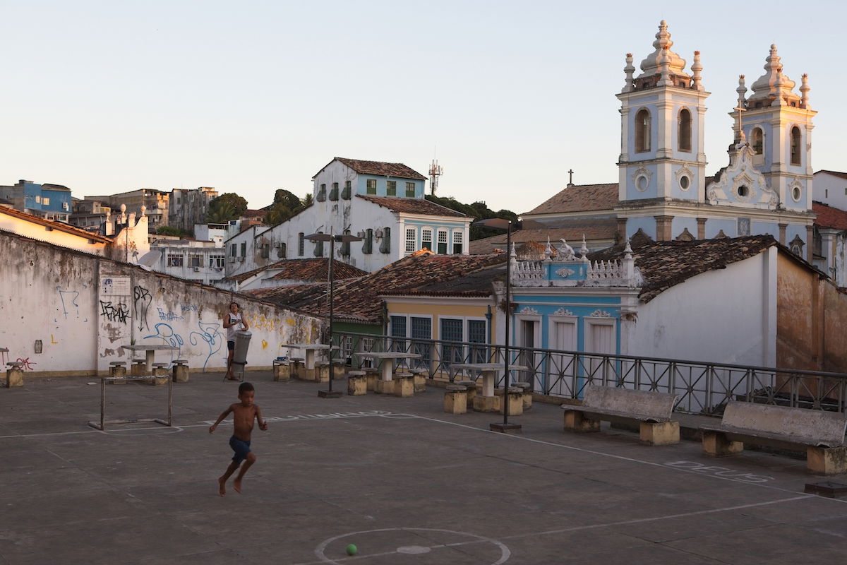 ON1 RAW image of boy playing in an urban courtyard in front of a church