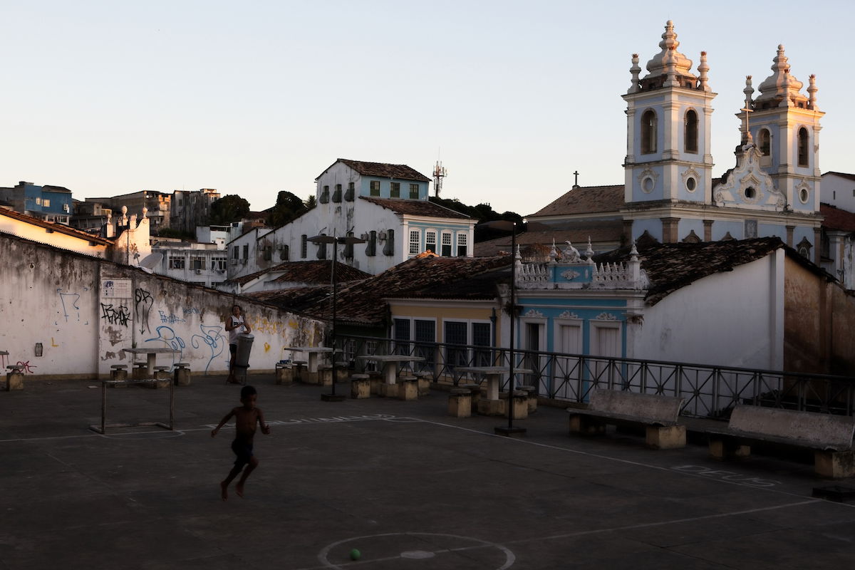 ON1 shadow adjustments to image of boy playing in an urban courtyard in front of a church