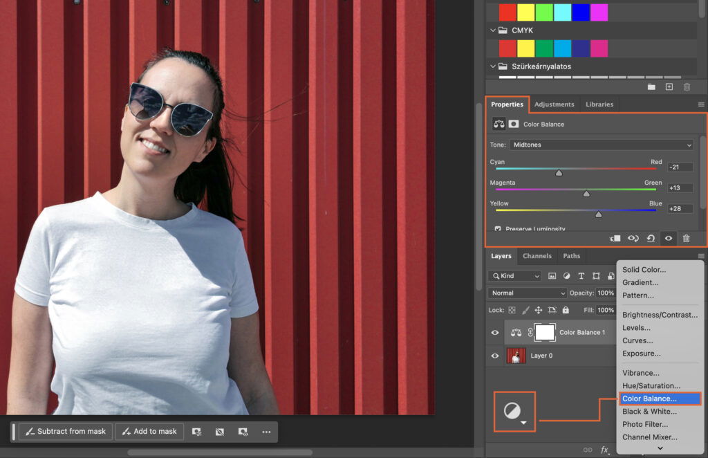 A woman stands against a red background, her image is open on a computer screen with an editing program. 