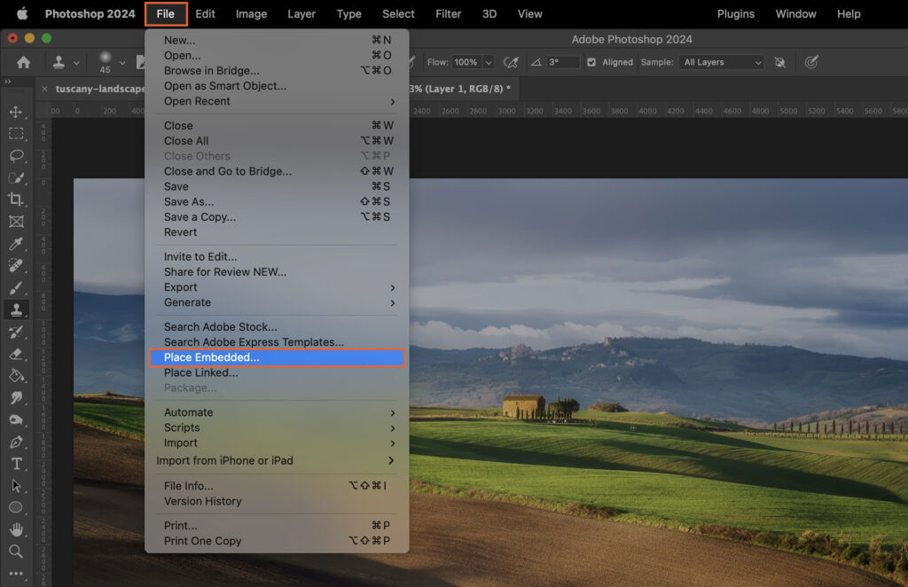 The Photoshop interface, with the cursor on an image of a rural landscape. 