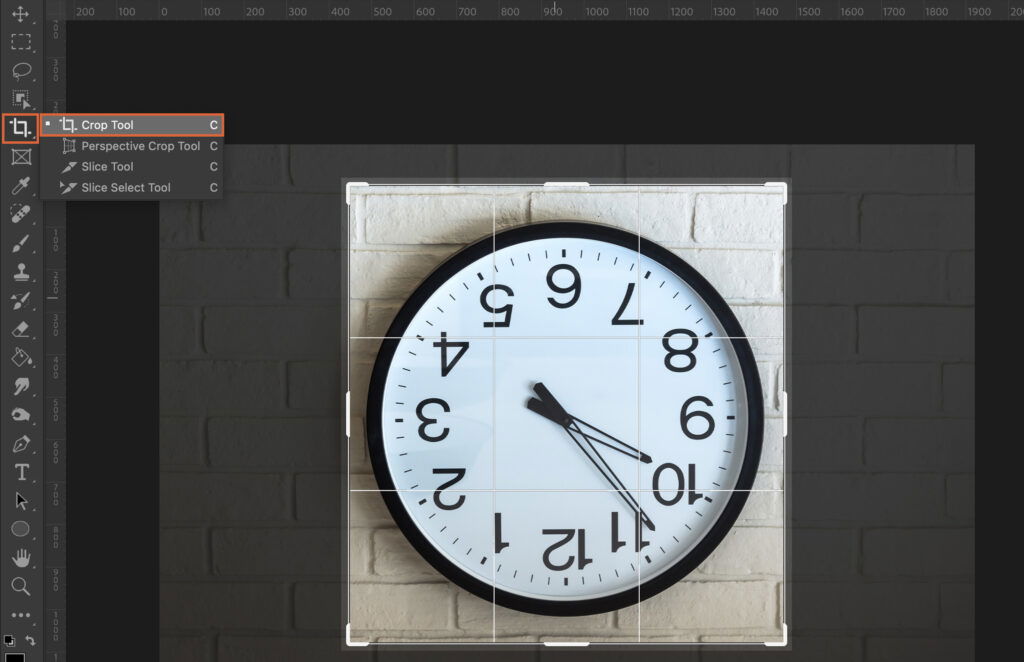 An analog clock against a brick wall background. 