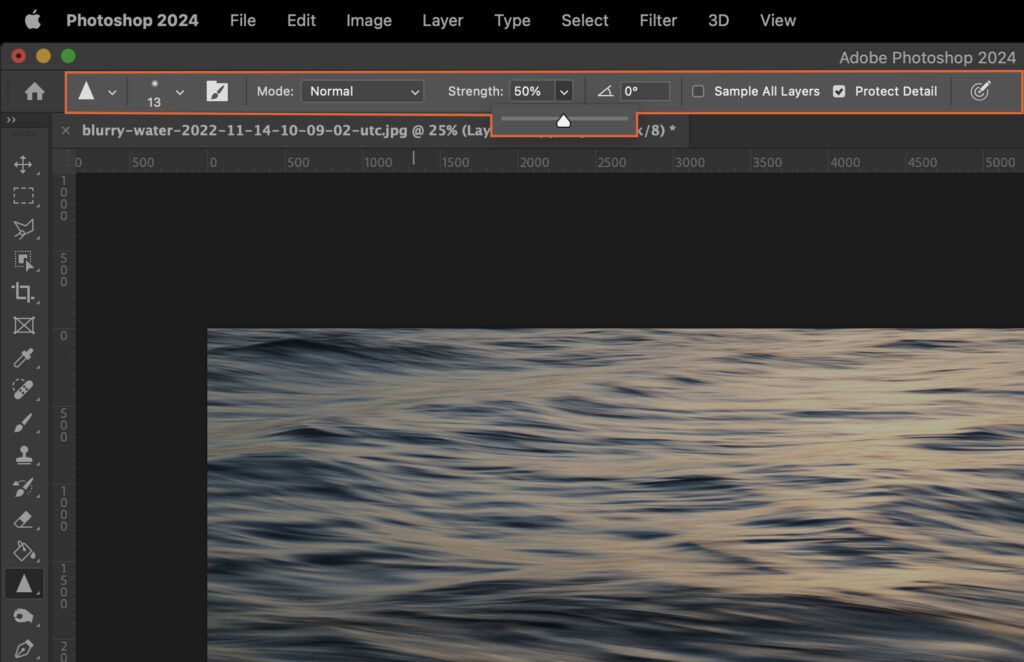 An Adobe Photoshop window with a water image open, showing the softwares interface and tools. 