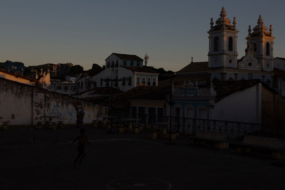 Image of boy playing in a courtyard beside a church at -4 exposure in Adobe Lightroom