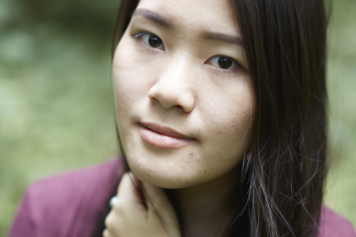 Portrait looking down on a woman with a blurred garden background