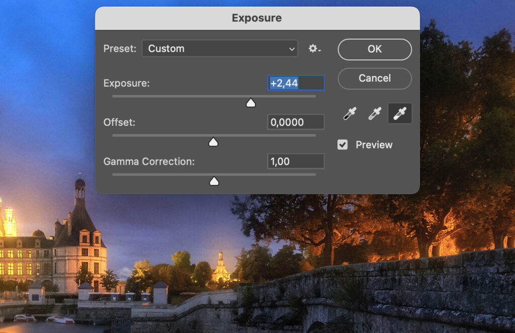 A graphic design program, where a user is adjusting the exposure settings on an image of a city at night. 