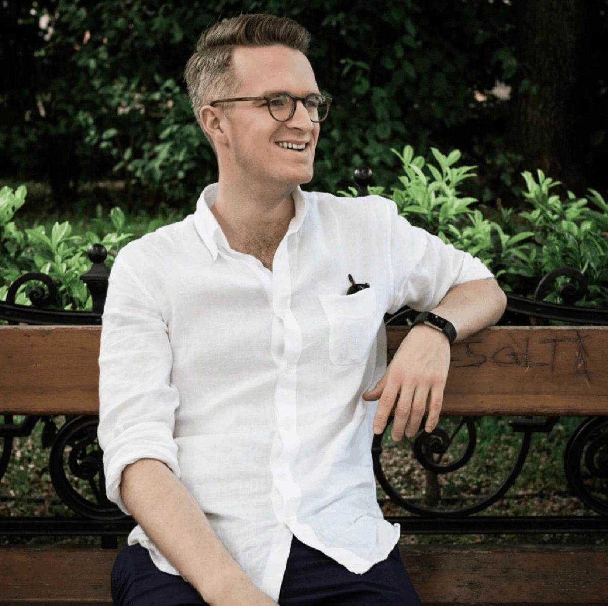 Image of Josh sitting on a bench in a white shirt