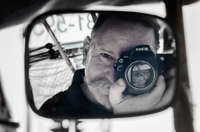 Mirror selfie of photographer in the back of a taxi