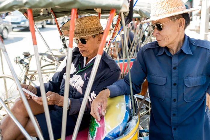 Two tuk tuk drivers taking a break