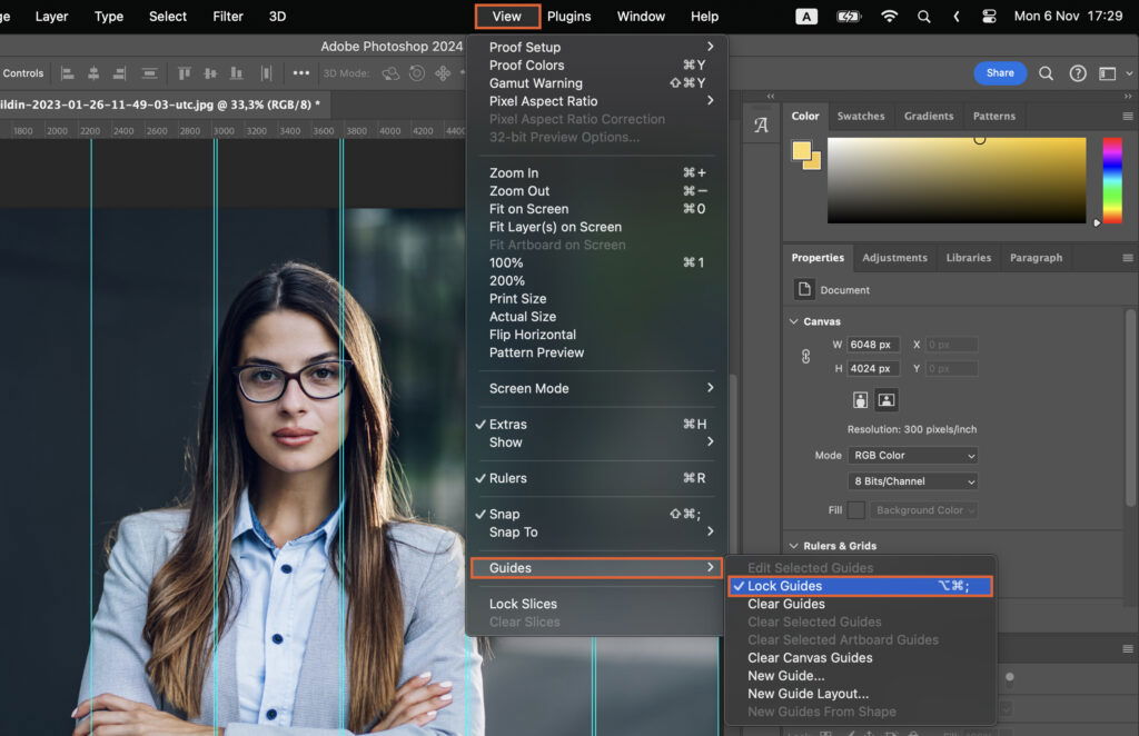 A woman posing in a promotional picture, with editing software open on the screen, where the subjects photo is being edited or prepared for production. 