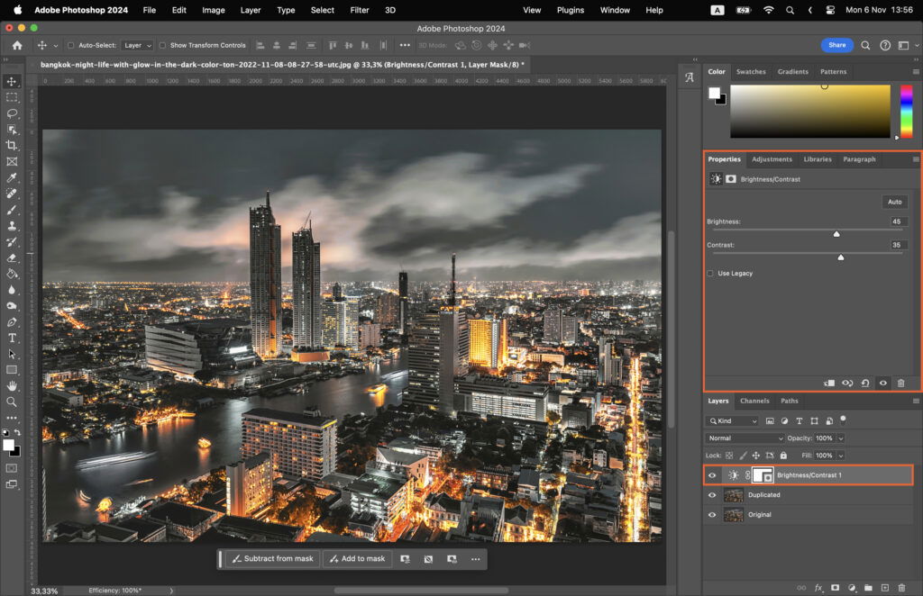 Adobe Photoshop software being used to edit a nighttime cityscape.