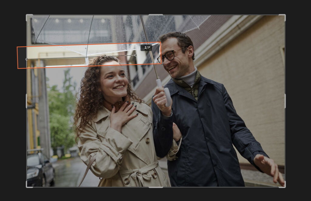 A couple on the street, both with umbrellas, posing for a picture. 