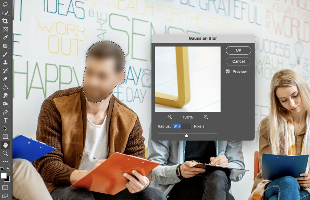 Adobe Photoshop interface open, displaying a photo of three people sitting together in a modern indoor setting. 