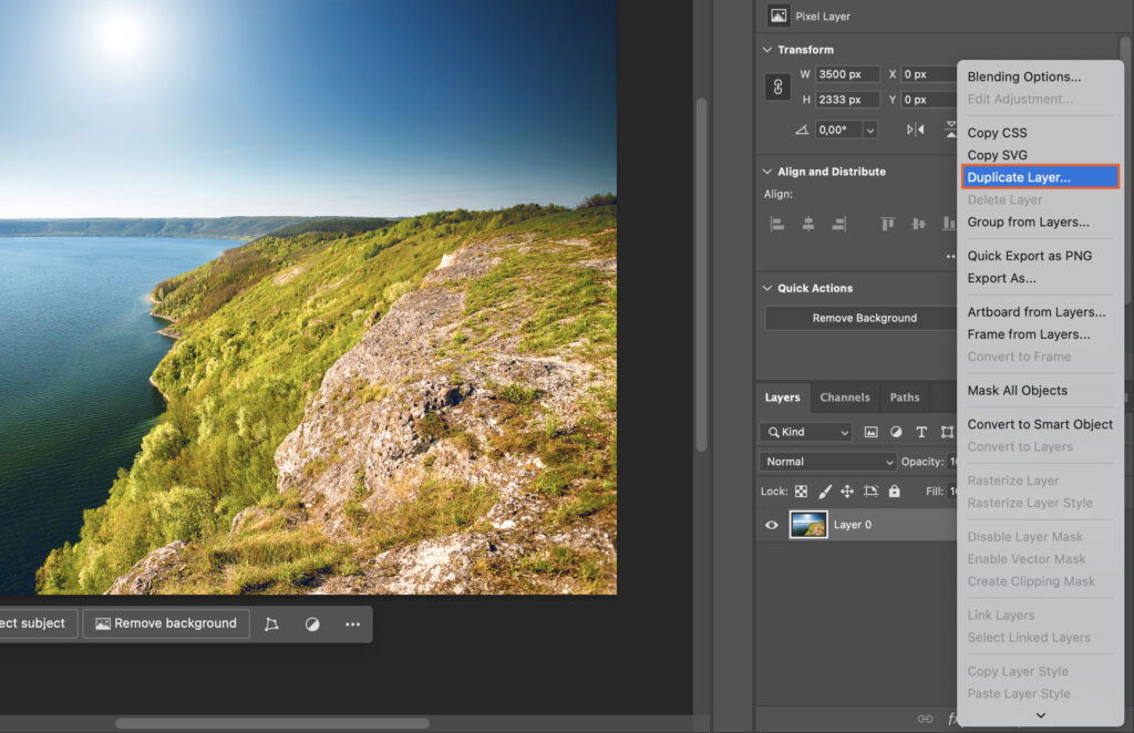 The Adobe Photoshop interface with the user working on a photo of a scenic landscape.