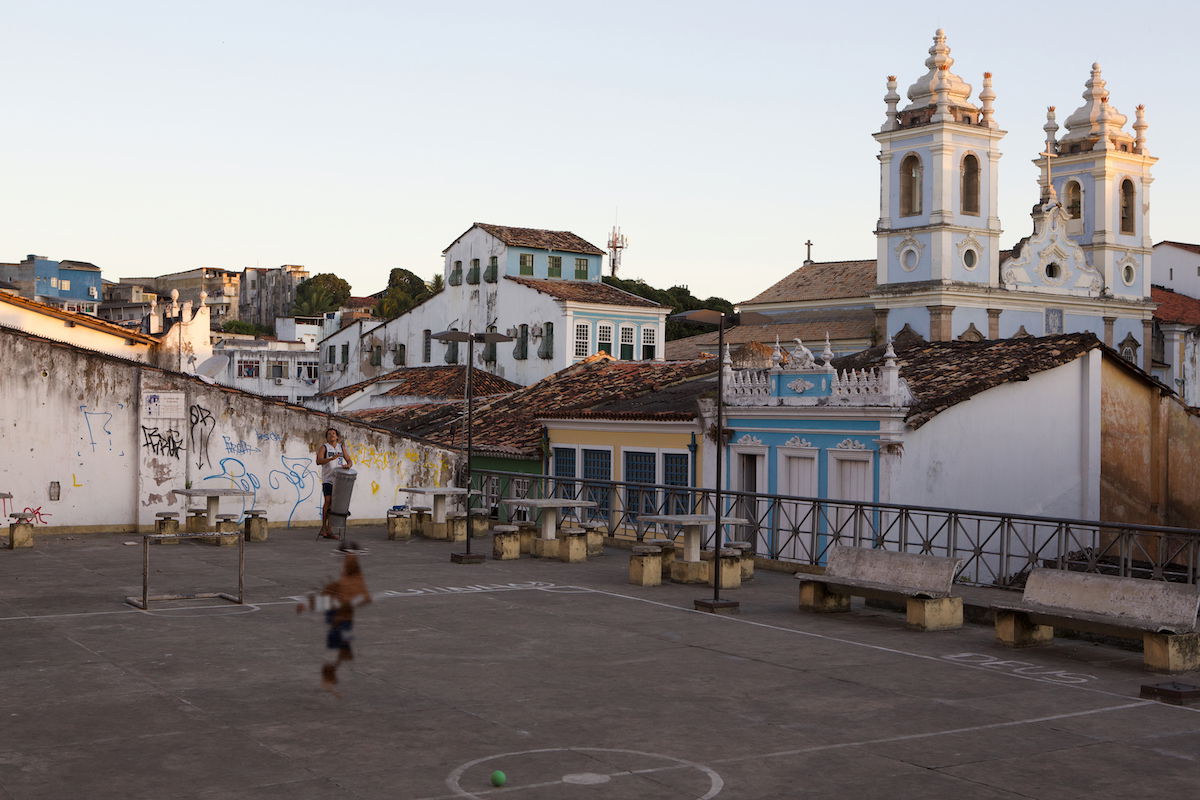 A boy playing in an urban square in front of a church partially removed with the Heal tool in ACDSee Photo Studio for Mac 10