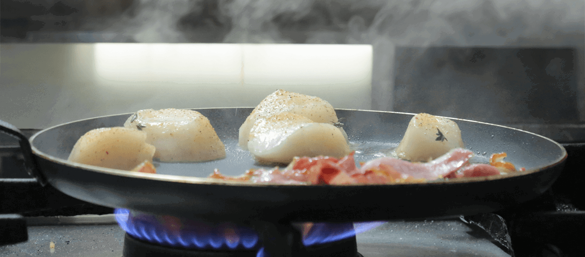 Scallops being cooked in a pan