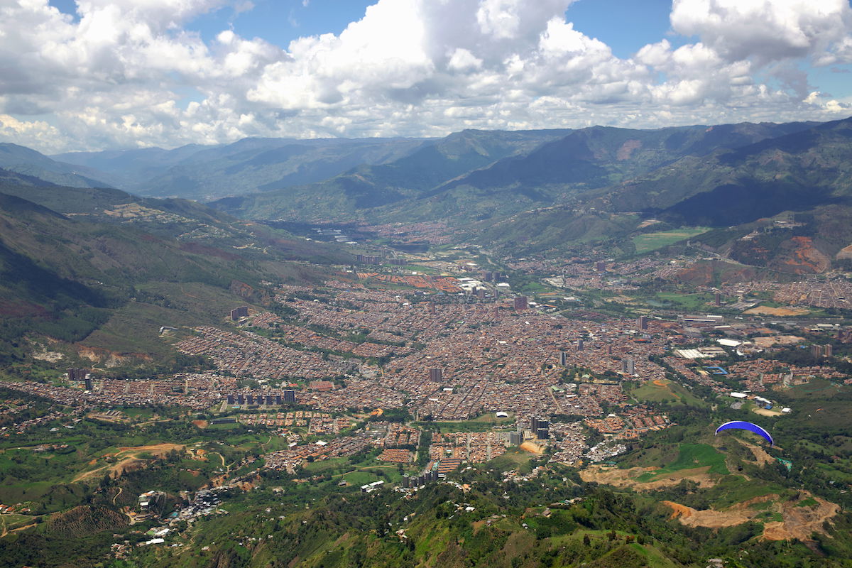 photograph taken from the sky showing a city with a paraglider in the lower corner edited on inPixio