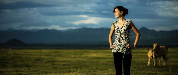 Cinematic portrait of woman in a field in front of cows