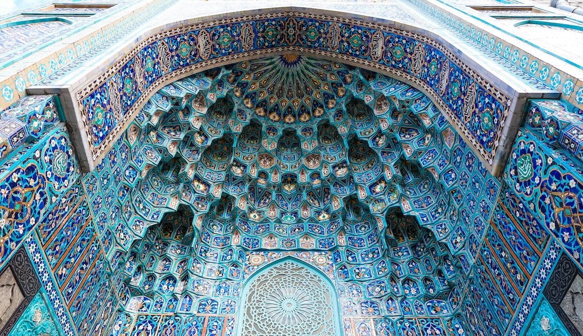 A beautiful blue and white tiled archway inside a mosque.