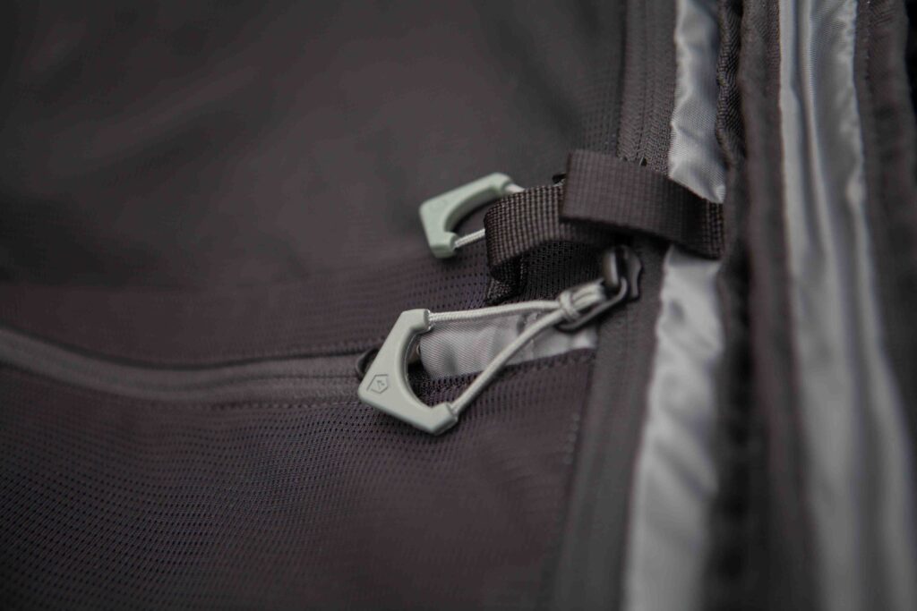 A close up of a black duffel bag with zips, tags and straps. 