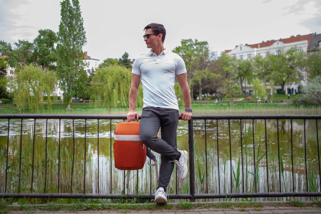 Man holding Nomatic Luma Camera Pack in his hand by a lake