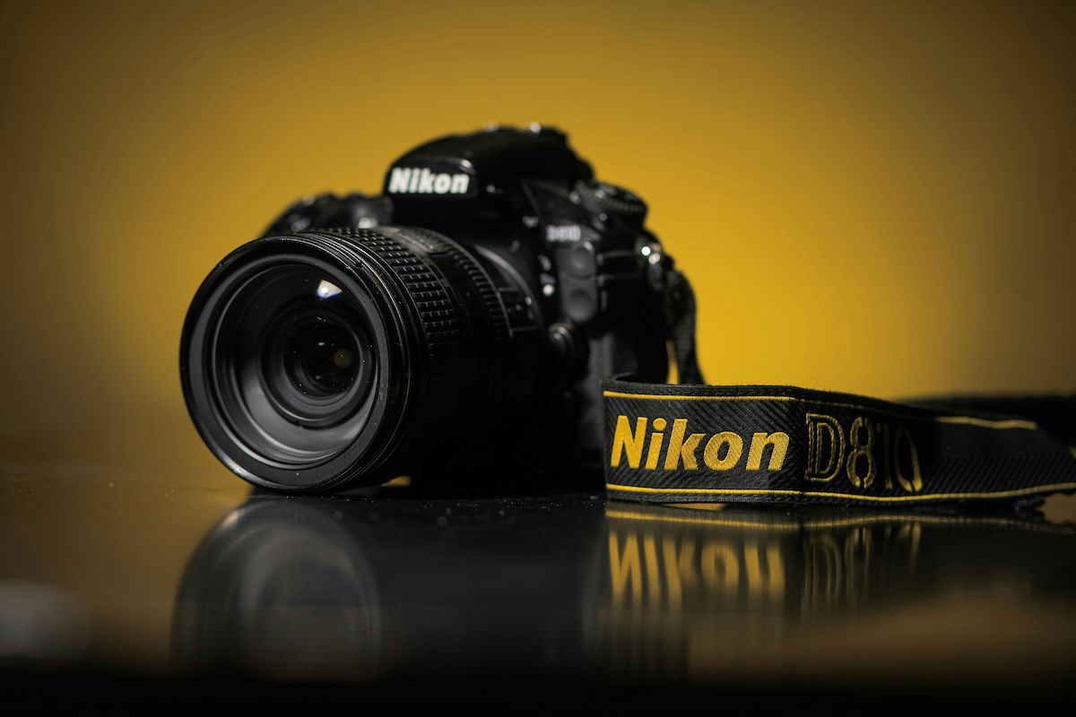 A Nikon camera with a yellow background.