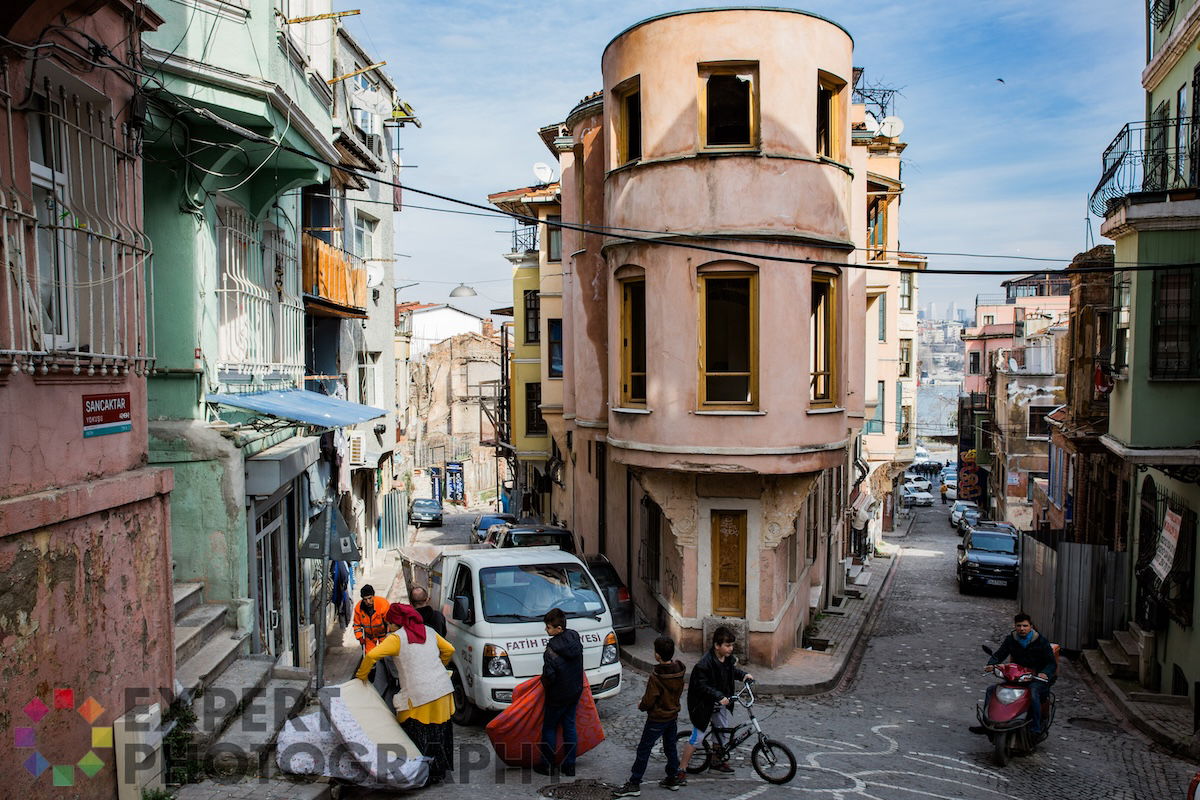 A sunny day in a bustling city street lined with old buildings.