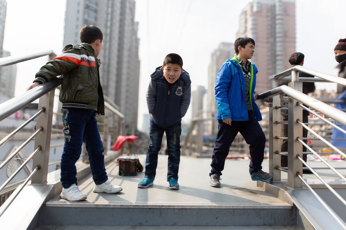 photograph of three boys on a bridge with background blurred